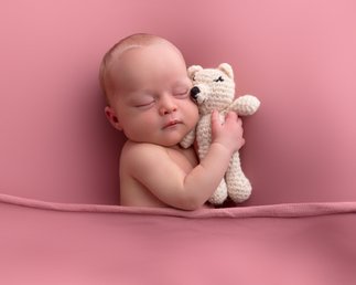 nyfødt jente med rosa blomsterkrans